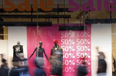 Photo from retail segment of a shop window with pink signs advertising 50% discount