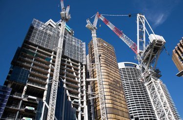 construction site with high-rise buildings and cranes seen from below