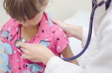 doctor examines a little girl with pink t-shirt with a stethoscope and does not need to use time on waste handling