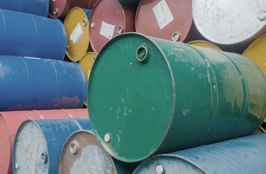 empty industry drums with green one in front