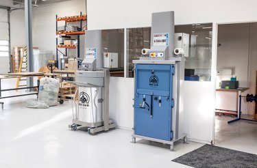 electric baler in working environment and grey compactor by its side