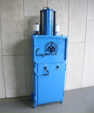 blue used baler standing against white wall